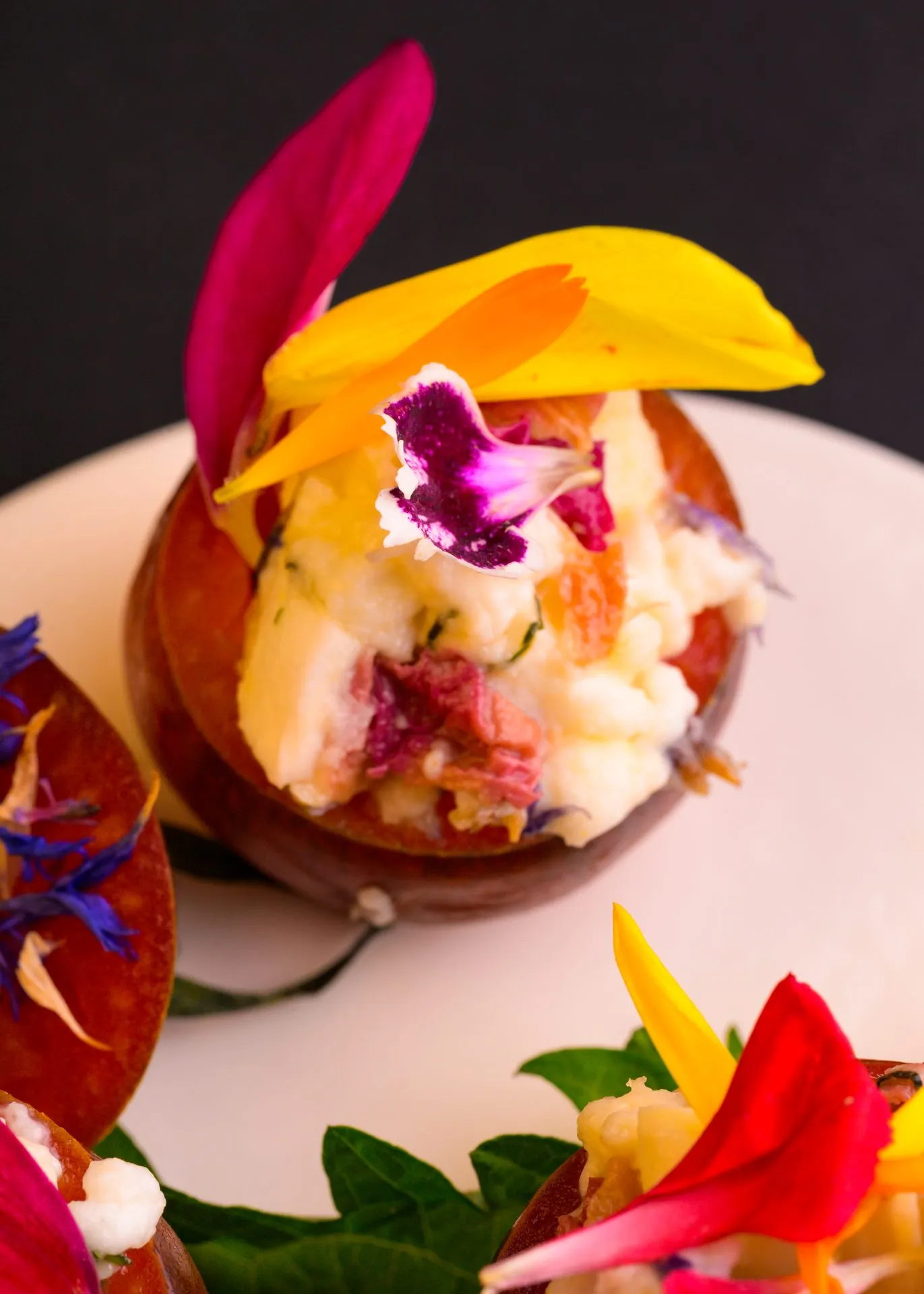 Bouchée garnie de crème et de fleurs comestibles, dressée à l'assiette