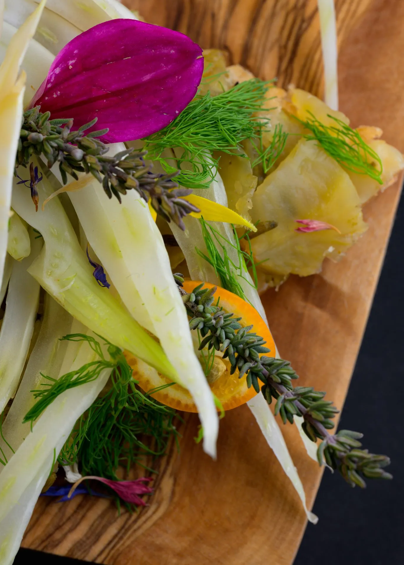 Fenouil, agrumes et brins de lavande dressés sur une planche en bois